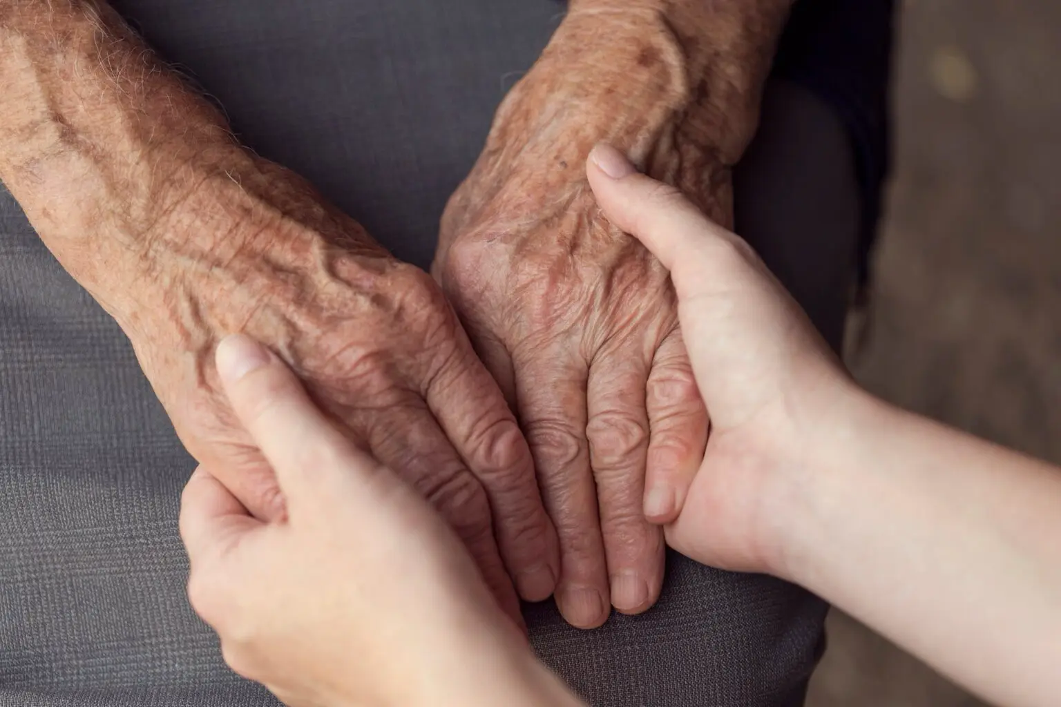 Pflegerin hält Hand von zu pflegender person